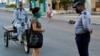Un policía hace chequeos de peatones el sábado en el barrio El Carmelo, que el gobierno anunció inicialmente que iba a aislar y luego mantuvo abierto por temor a que se hiciera aún más difícil el acceso a provisiones, según reporta el diario 14ymedio (Foto: Yamil Lage/AFP).