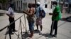 En esta foto tomada el 8 de julio en la barrera de acceso a un barrio habanero, un policía habla con personas que se disponían a pasar a una zona restringida (Foto: Alexandre Meneghini/Reuters).